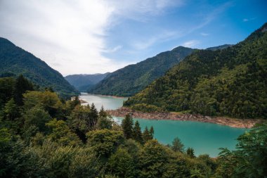 Emerland water reservoir on the way to Mestia. Beautiful panoramic view of Inguri lake surrounded by pine forest and mountains. Summer, weather.