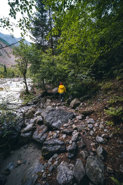 穿着黄色夹克的女人 游客徒步径直奔向查拉迪冰川 在波涛汹涌的背景下 佐治亚州的梅斯蒂亚河 旅行和休假概念 — 图库照片