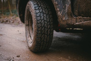 Off-road lastiğine yakın. Çeşitli yüzeylerin koruyucusu, evrensel. Çamur, taşlar, köy yolu. Tüm tekerden çekişli araç. 4x4 SUV toprak yolda. Seçici odak