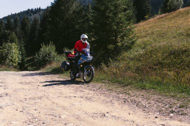 Seyahat eden motosikletçi, yaz günü, motosiklet off road, maceralı sürücü, yan çantalı motosiklet turu, ekstrem turizm, spor kıyafetleri, Karpatlar dağları Ukrayna