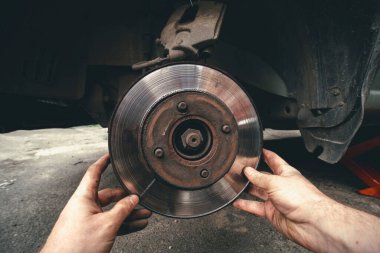 Disk freni ve araba servisi konsepti - Araç fren pedi değiştirme servisi arabadaki tamircinin eliyle, bunu kendin yap, kendim. Eski