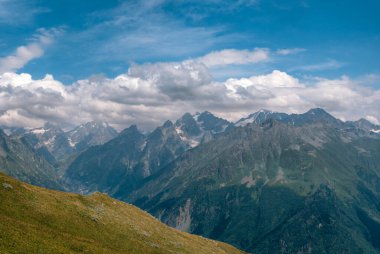 Dağın tepelerini, ılık yaz günlerini, gökyüzündeki bulutları, Ushba Dağı 'na ve Koruldi göllerine giden yolu. Tatil ve Georgia 'ya seyahat kavramı. Doğa, Mestia, Svaneti Dağları