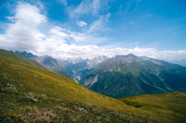 Dağın tepelerini, ılık yaz günlerini, gökyüzündeki bulutları, Ushba Dağı 'na ve Koruldi göllerine giden yolu. Tatil ve Georgia 'ya seyahat kavramı. Doğa, Mestia, Svaneti Dağları