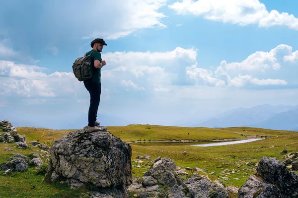모자와 배낭을 여행하는 남자가 경치를 즐기는 중이야 조지아의스 코카서스의 산에서의 — 스톡 사진
