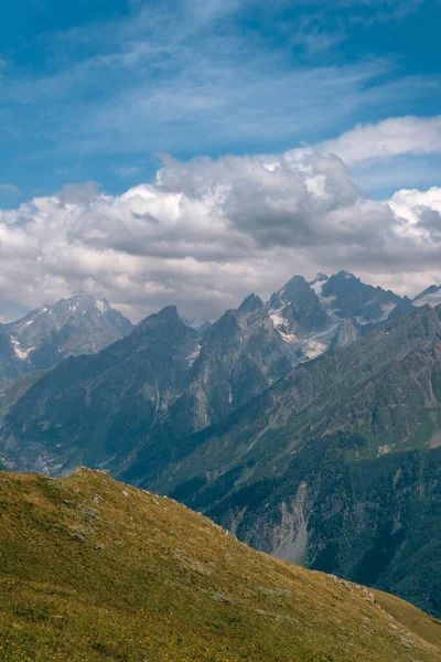 stock image View of mountain tops, warm summer day, clouds in the sky, way to Ushba mountain and Koruldi lakes. Concept of vacation and travel to Georgia. Nature, Mestia, Svaneti mountains. Vertical photo