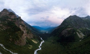 Yüksek Kafkas dağları arasında Shdugra şelalesinin hava manzarası, arka planda Ushba Dağı. Vadi. Dolra Dağı 'nın fırtınalı akışı. Yaz tatili, Mazeri, Georgia 'da yürüyüş.