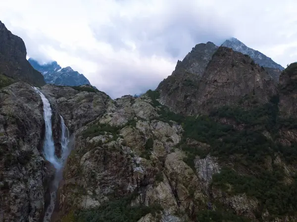 乌什比瀑布在高加索山脉间的空中全景 多拉山河湍急流淌 在格鲁吉亚徒步旅行 图库照片
