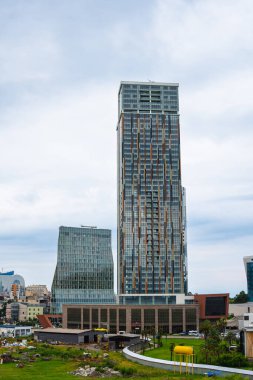 Batumi, Georgia - August 13 2021: view of downtown with Porta Batumi Tower. Construction, tall buildings, glass, metal and concrete, sky, summer day. Vertical photo