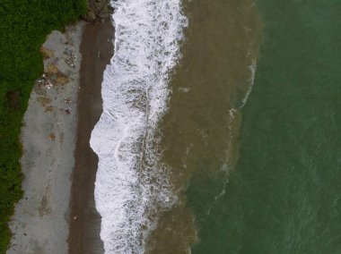 Yazın gün batımında sakin sahil kıyısı olan Karadeniz kıyısı manzaralı havadan panoramik manzara. Yağmur bulutları, fırtına. Tsikhisdziri Gürcistan 'daki gizli kumsalda demiryolu.
