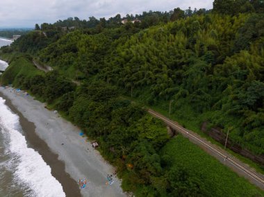 Yazın gün batımında sakin sahil kıyısı olan Karadeniz kıyısı manzaralı havadan panoramik manzara. Yağmur bulutları, fırtına. Tsikhisdziri Gürcistan 'daki gizli kumsalda demiryolu.