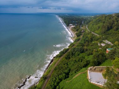 Yazın gün batımında sakin sahil kıyısı olan Karadeniz kıyısı manzaralı havadan panoramik manzara. Fırtına. Gürcistan 'da Tsikhisdziri ve Kobeleti gizli plajları. Demiryolu.