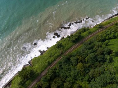 Yazın gün batımında sakin sahil kıyısı olan Karadeniz kıyısı manzaralı havadan panoramik manzara. Fırtına. Gürcistan 'da Tsikhisdziri ve Kobeleti gizli plajları. Demiryolu.