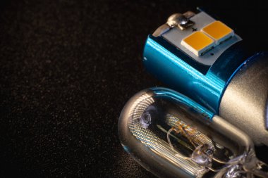Mavi kutsanmış alüminyum üzerine diyot yayan araba ampulü, ısı dağılımı, halojen, aksesuarlar ve elektronik araçlar için bileşenler. kopyalama alanı. Siyah arka plan yakın plan. 12V T10