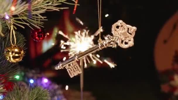 家やスパークラーからのゴールデンキー 2024年に新しい不動産を購入する 新年とメリークリスマス 本物のクリスマス クリスマスツリー おもちゃ ガーランド — ストック動画