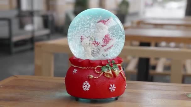 圣诞老人和圣诞礼物还有在街上咖啡馆里的雪球熊雪顶 玻璃球 — 图库视频影像