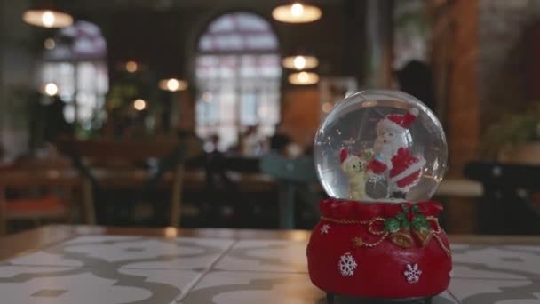 复制空间 圣诞老人和圣诞礼物还有雪球里的熊在咖啡馆里雪顶 玻璃球 — 图库视频影像
