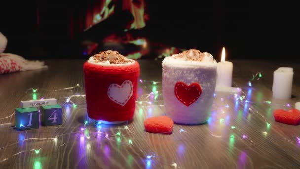 圣瓦伦丁节热巧克力可可饮料加棉花糖 舒适的氛围与壁炉 格子花 花环和蜡烛 为杯子编织的盖子 有一颗心 — 图库视频影像