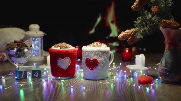 圣瓦伦丁节视频明信片 热巧克力可可饮料加棉花糖 舒适的氛围与壁炉 格子花 花环和蜡烛 为杯子编织的盖子 有一颗心 — 图库视频影像