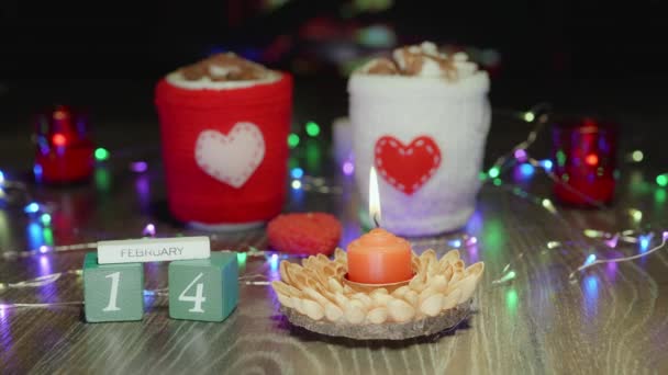 聖バレンタインデー ハンドメイドキャンドルとカレンダー マシュマロでホットチョコレートココアドリンク ガーランド ろうそくが付いている居心地の良い雰囲気 ハートのあるカップのための編まれたカバー — ストック動画