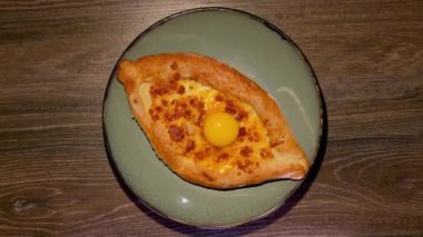 Ev yapımı Adjarian Khachapuri. Yemek geldi. Gürcistan mutfağı geleneksel yemekler, ev yapımı yemekler. Yumurtalı Khachapuri..