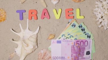 Yolculuk için para, tatil, dinlenme, tatil, hayal, seyahat. Pahalı bir sahil beldesinde hak edilmiş bir tatil. Sahilde Euro. Kumun üstündeki yazıt 