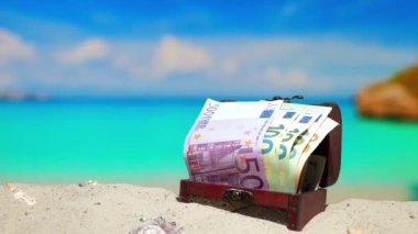 Uzayı kopyala Güzel sahil plajı. Tatil ve tatil için Euro parasıyla dolu bir sandık. Avrupa tatil beldesinde tatil. Kıyıdaki gök mavisi suyu. İtalya, İspanya, Grece, Girit, Türkiye, Karadağ Avrupa Birliği tatil beldeleri
