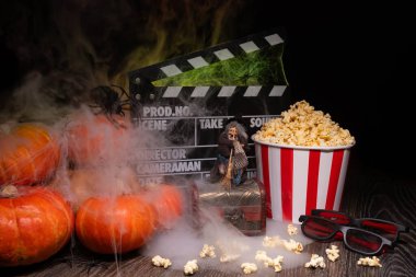 Cinema Theater Poster: Film Clapperboard, Watching Film Movie. Movie genre: horror, nightmares. Popcorn and Glasses from Cinema Theater. Halloween scene: Pumpkins, Mist, Fog, Smoke, Fire and Spiders clipart