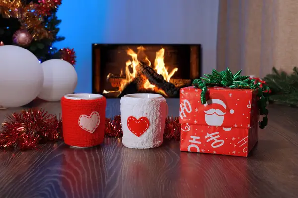 Örgü kapaklı kupalar. Aşk, kalpler. Noel ve Yeni Yıl Hediyesi Ağacın Altında Çelenk ve süslerle. Noel Dekorasyonu Sıcak Tatil Atmosferi Oluşturuyor.