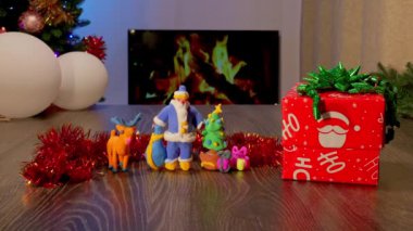 Plasticine handmade child toys. Christmas and New Year Gift Under the Tree with Garland and Ornaments. Festive Fireplace with Christmas Decor Creating a Cozy Holiday Atmosphere.