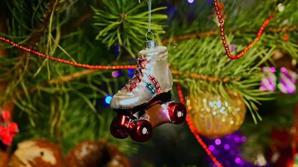 Paten kayıyoruz. Mutlu Noeller ve mutlu yıllar. Noel Ağacı Oyuncak Süslemeleri. Işıklar ve çelenklerle süslenmiş, Eşsiz Noel Ağacı 'ndaki Şenlikli Sahne. Sıcak Tatil Kartpostalı