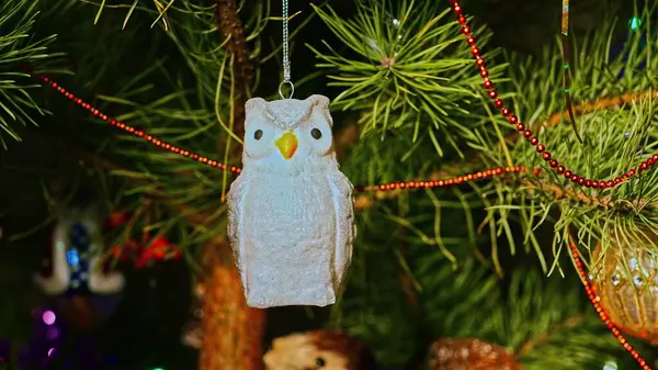 Baykuş. Mutlu Noeller ve mutlu yıllar. Noel Ağacı Oyuncak Süslemeleri. Işıklar ve çelenklerle süslenmiş, Eşsiz Noel Ağacı 'ndaki Şenlikli Sahne. Sıcak Tatil Kartpostalı