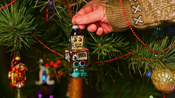 Robot! Mutlu Noeller ve mutlu yıllar. Noel Ağacı Oyuncak Süslemeleri. Işıklar ve çelenklerle süslenmiş, Eşsiz Noel Ağacı 'ndaki Şenlikli Sahne. Sıcak Tatil Kartpostalı