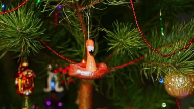 Pembe flamingo. Noel ağacını süsleyen bir adam, yılbaşı süveteri giyen bir adam. Yeni yıl ve mutlu Noeller. Oyuncaklar ve çelenklerle Noel ağacı yaşa.