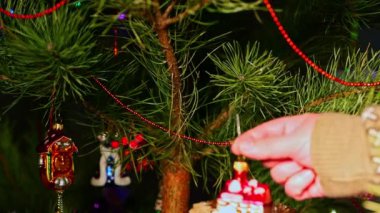 Ev, emlak. Noel ağacını süsleyen bir adam, yılbaşı süveteri giyen bir adam. Yeni yıl ve mutlu Noeller. Oyuncaklar ve çelenklerle Noel ağacı yaşa.