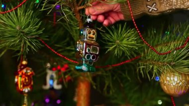 Robot! Noel ağacını süsleyen bir adam, yılbaşı süveteri giyen bir adam. Yeni yıl ve mutlu Noeller. Oyuncaklar ve çelenklerle Noel ağacı yaşa.