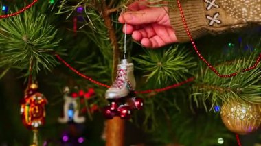 Paten kayıyoruz. Noel ağacını süsleyen bir adam, yılbaşı süveteri giyen bir adam. Yeni yıl ve mutlu Noeller. Oyuncaklar ve çelenklerle Noel ağacı yaşa.