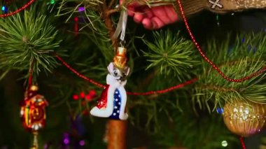 Fare. Noel ağacını süsleyen bir adam, yılbaşı süveteri giyen bir adam. Yeni yıl ve mutlu Noeller. Oyuncaklar ve çelenklerle Noel ağacı yaşa.
