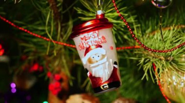 Kahve fincanı. Noel ağacı süslemeleri. Yeni yıl ve mutlu Noeller. Pürüzsüz kamera hareketi. Video kartpostalı. Noel ağacında çelenkler ve oyuncaklar