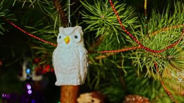 Gümüş baykuş. Noel ağacı süslemeleri. Yeni yıl ve mutlu Noeller. Pürüzsüz kamera hareketi. Video kartpostalı. Noel ağacında çelenkler ve oyuncaklar