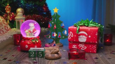 Yılan - Çin Ay takviminde 2025 Yılın Sembolü. Noel Hediyesi Kutusu, Noel Ağacı, Noel Baba 'lı Cam Kar Küresi, Kırmızı Mumlar ve 25 Aralık' ta İşaretli Takvim.