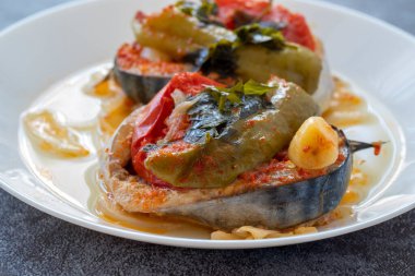 Lezzetli geleneksel Türk balığı yemeği, Palamut Pilaki. Beyaz tabakta büyük bir balık tabağının sunumu. Üst çekim.