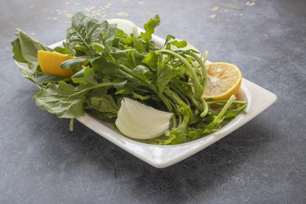 Salade Roquette Fraîche Dans Une Assiette Blanche Sur Fond Pierre — Photo
