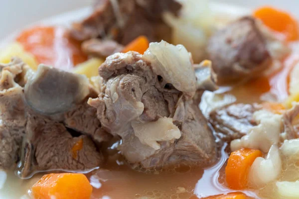 stock image Boiled lamb meat with potatoes, carrots , onions, top view, copy space. Homemade winter comfort food.