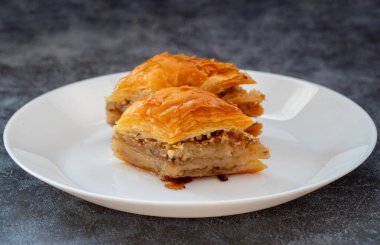 Beyaz tabakta ceviz baklavası. Türk usulü ceviz baklavası sunumu ve servisi. Yatay görünüm.