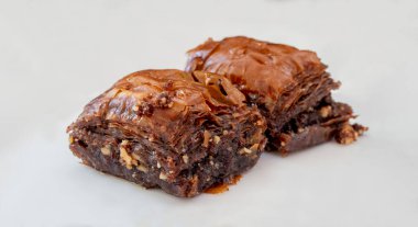 Beyaz tabakta çikolatalı baklava. Türk usulü çikolata baklava sunumu ve hizmeti. Yatay görünüm.