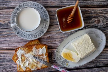 Türk kahvaltısı için pıhtılaşmış krema (tereyağı kreması) - Kaymak, bal ve bir bardak süt