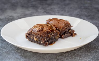Beyaz tabakta çikolatalı baklava. Türk usulü çikolata baklava sunumu ve hizmeti. Yatay görünüm.