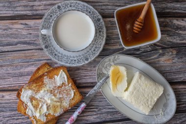 Türk kahvaltısı için pıhtılaşmış krema (tereyağı kreması) - Kaymak, bal ve bir bardak süt
