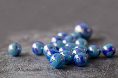 Glass colored marble balls , glass balls isolated on gray background . Children's play equipment.
