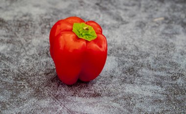 Gri arkaplanda kırmızı renkli dolma biber .